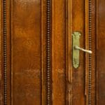 Drewniane drzwi pokojowe z rzeźbieniami i mosiężną klamką