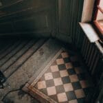 Stare schody z czarno-białą posadzką i ozdobną metalową balustradą