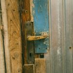 Zbliżenie na stare drewniane drzwi z przetartą klamką