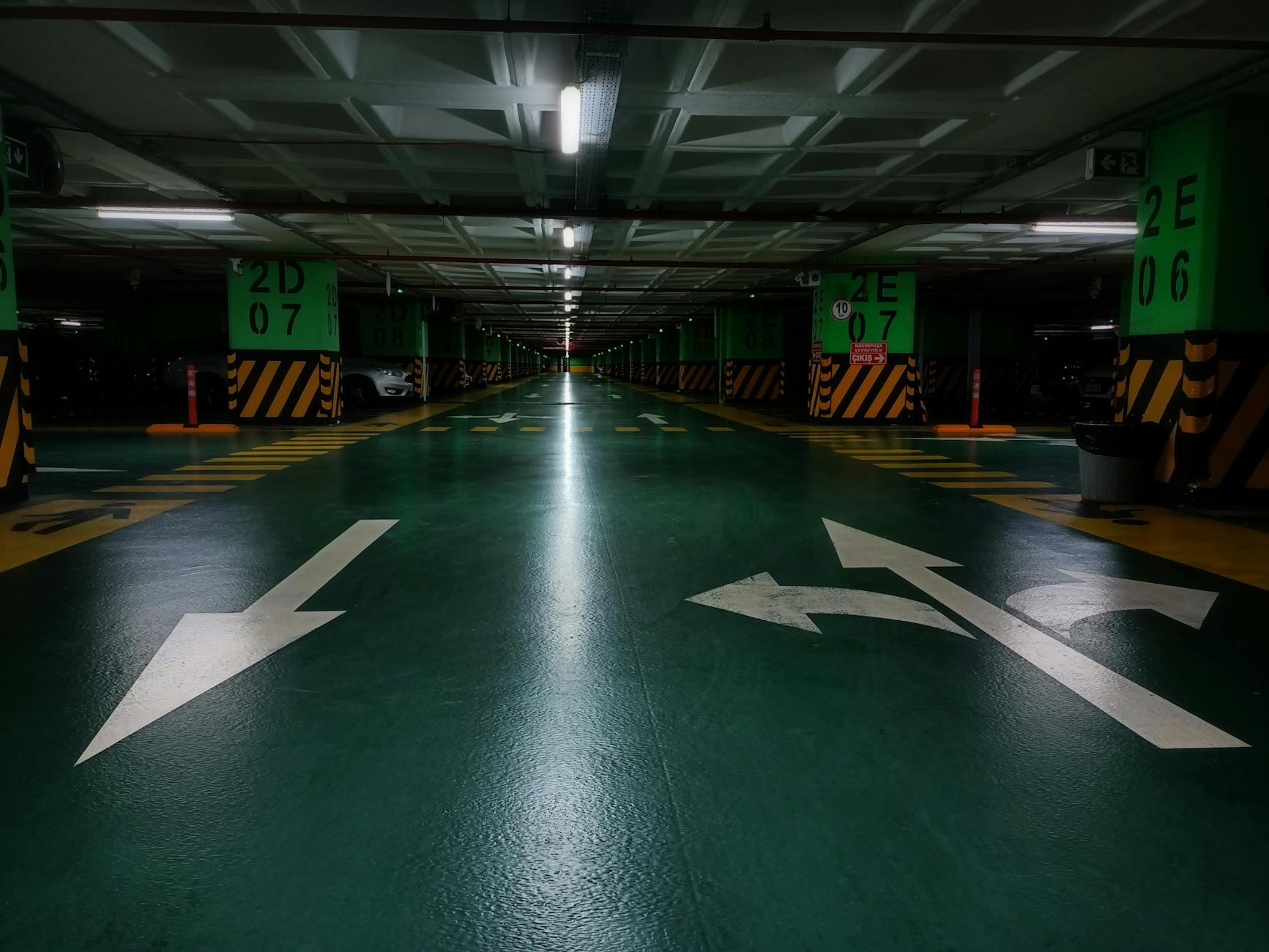 Podziemny parking z zielonym oznakowaniem na podłodze