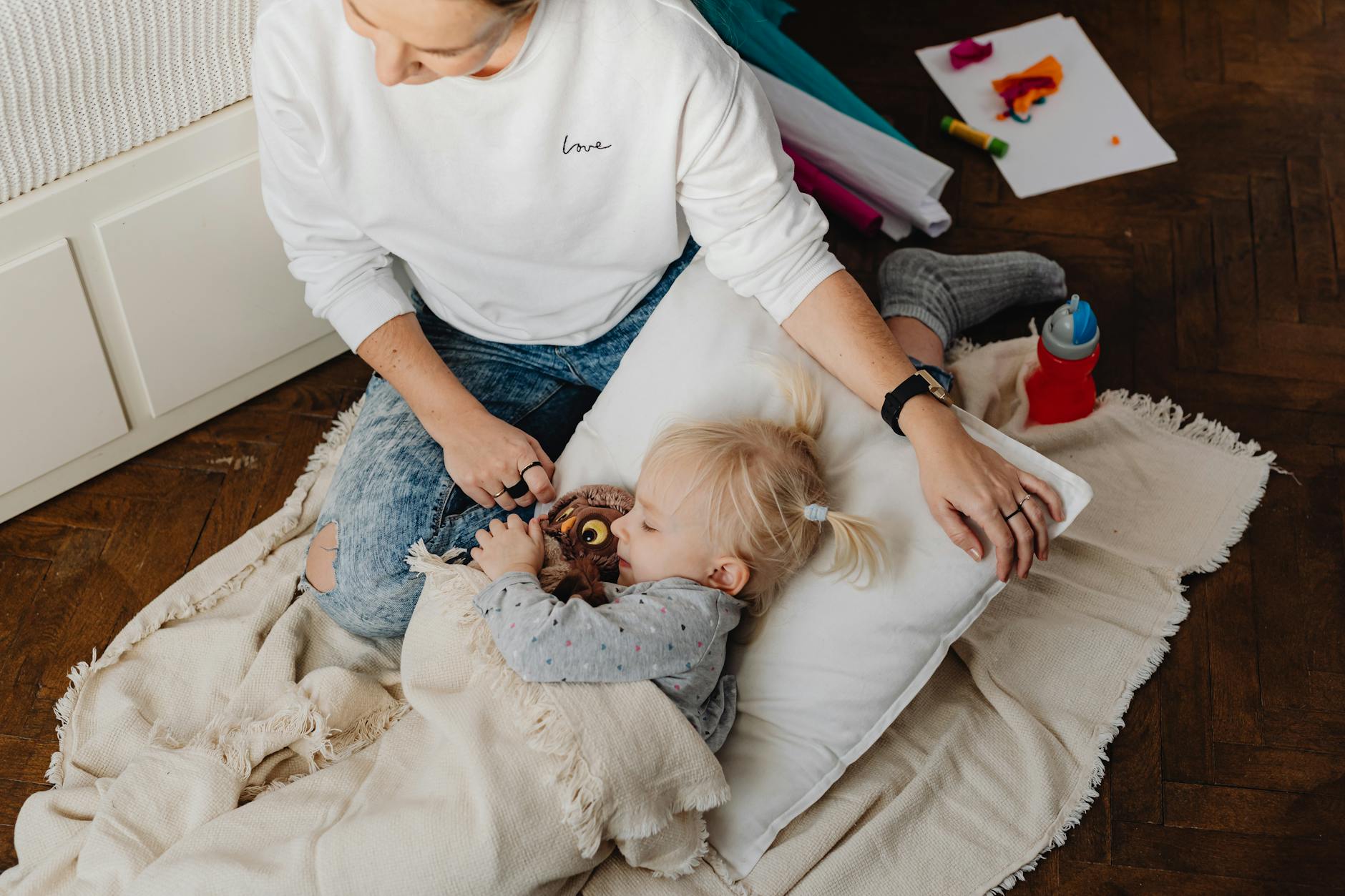 Mama czule przytula śpiącą córkę w ciepłej, bezpiecznej atmosferze