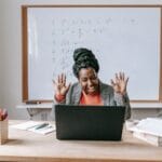 Nauczycielka online prowadzi lekcję na laptopie w nowoczesnej klasie