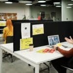 Pracownicy w nowoczesnym biurze podczas zdalnej współpracy nad projektami