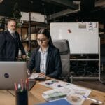 Specjaliści omawiają dokumenty przy laptopie w nowoczesnym biurze