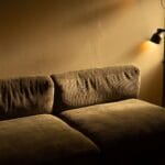 Sztruksowa sofa w przyciemnionym, przytulnym salonie sprzyjającym ciszy