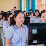 Uczniowie w pracowni komputerowej uczą się programowania AI